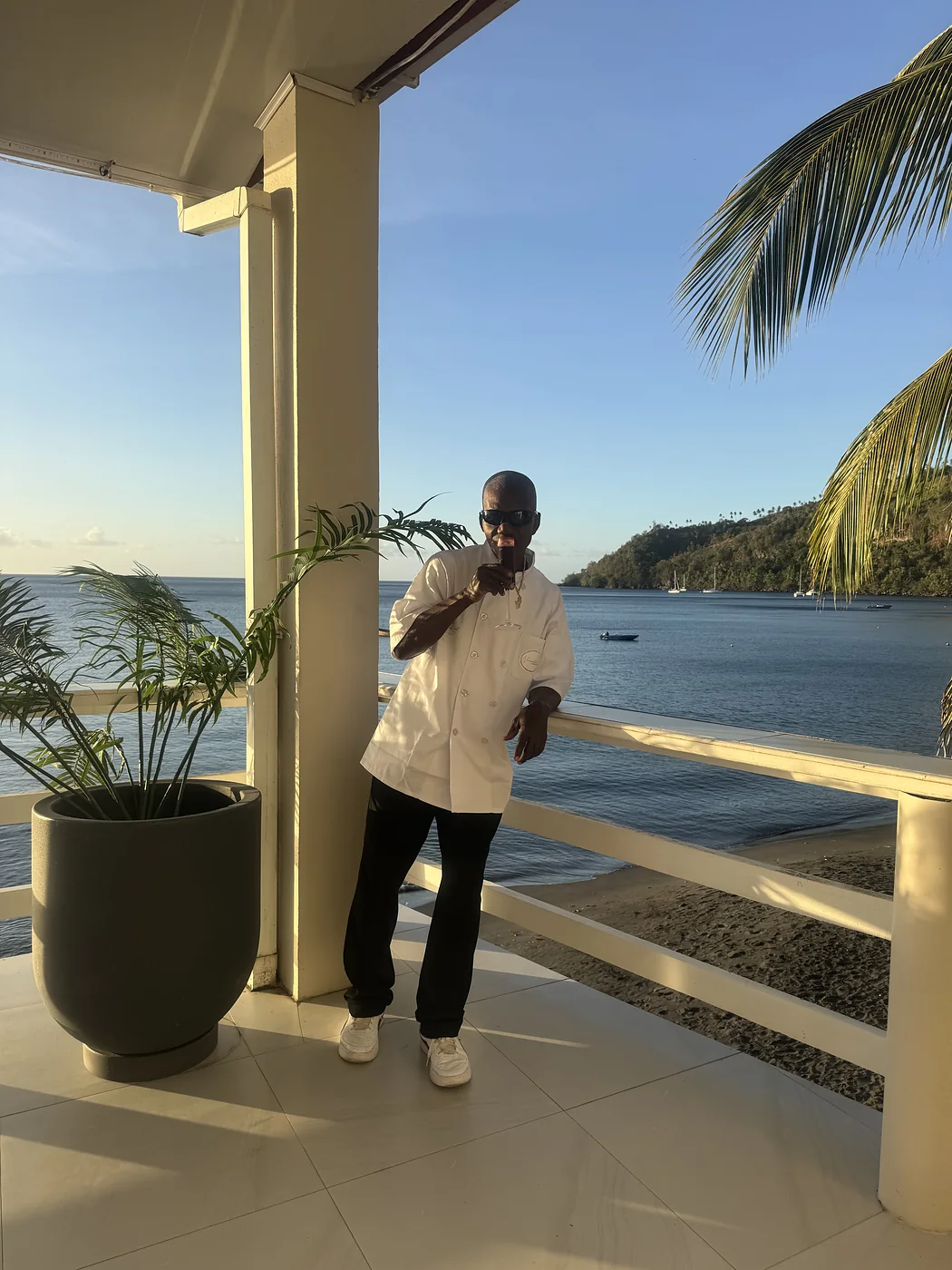 Verandah chef on the terrace as the sun sets over Chateaubelair bay