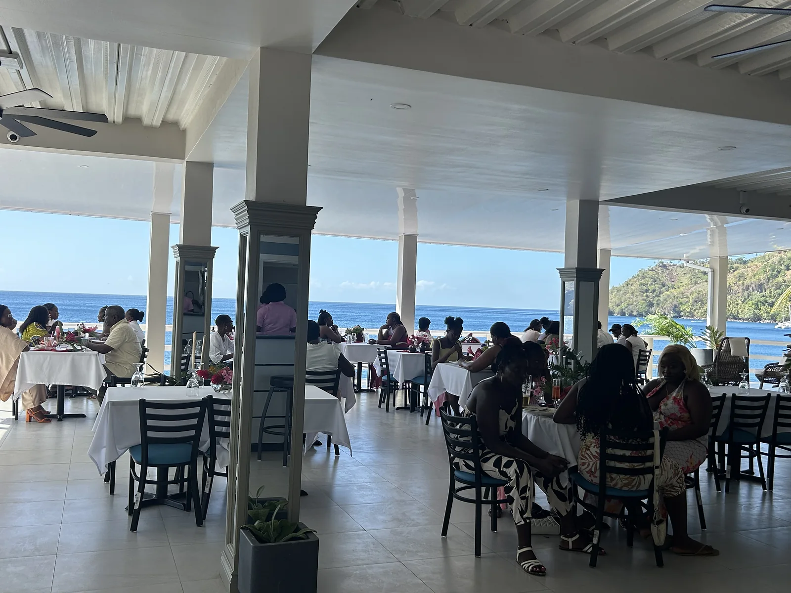 Guests dining on the Verandah with the Caribbean Sea beyond