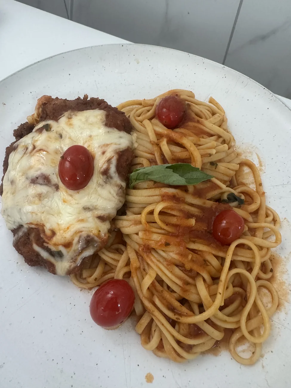Chicken parmesan with melted cheese served over herbed pasta at Verandah