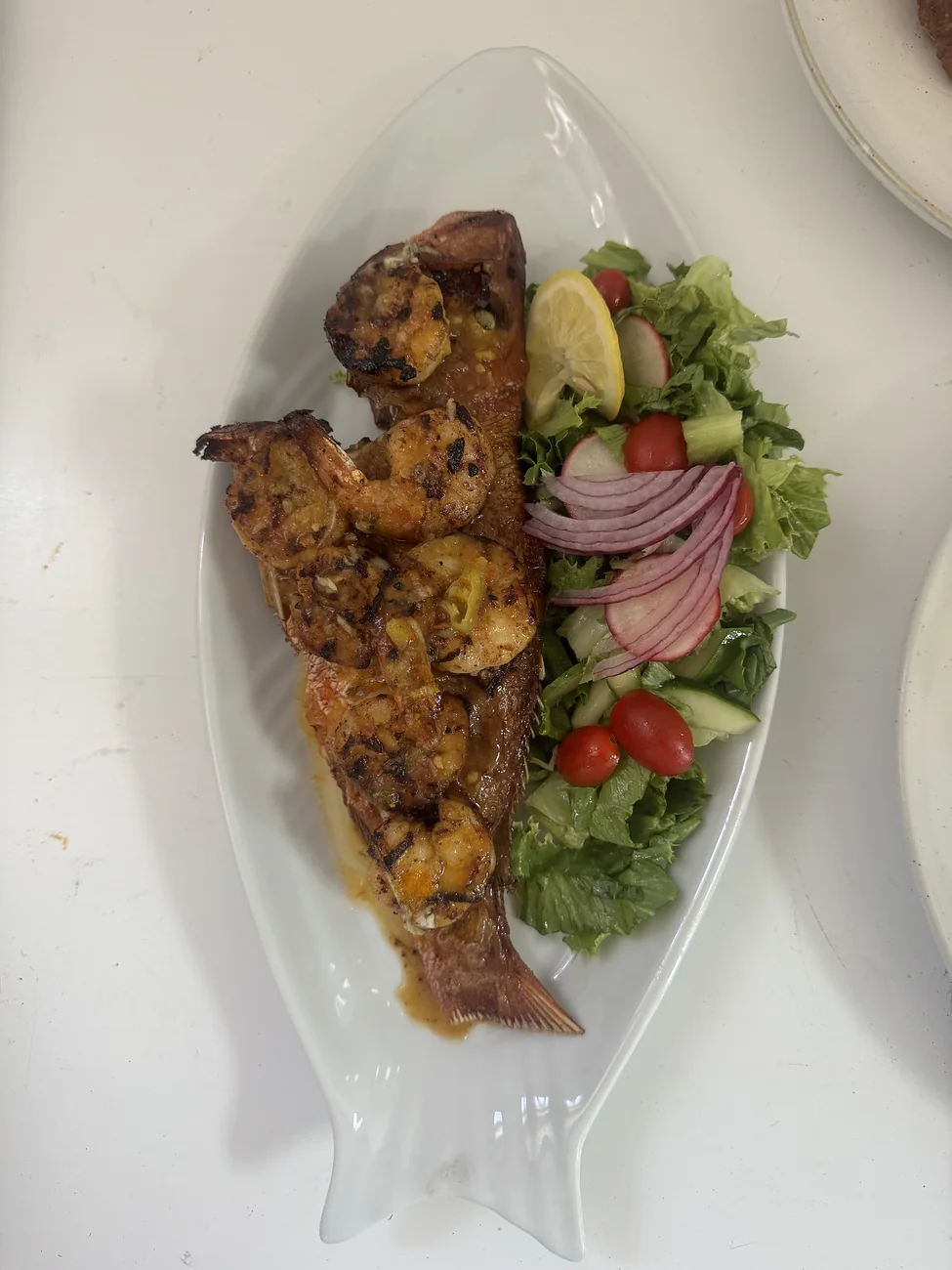 Crispy fried snapper topped with blackened shrimp and served with salad at Verandah