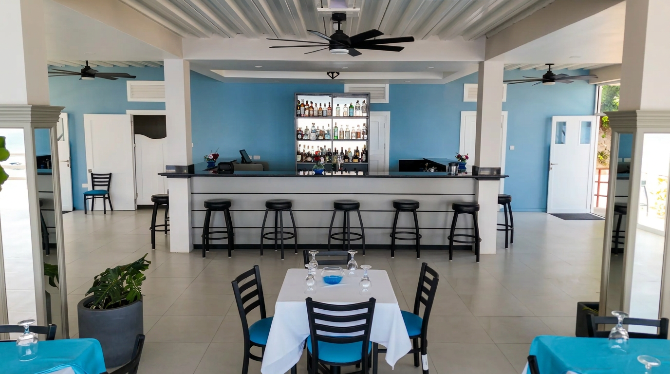 The Verandah bar and dining room with linen-set tables and open sea views